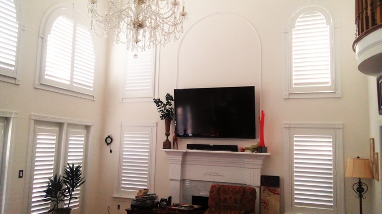 Denver great room with mounted TV and arched windows.